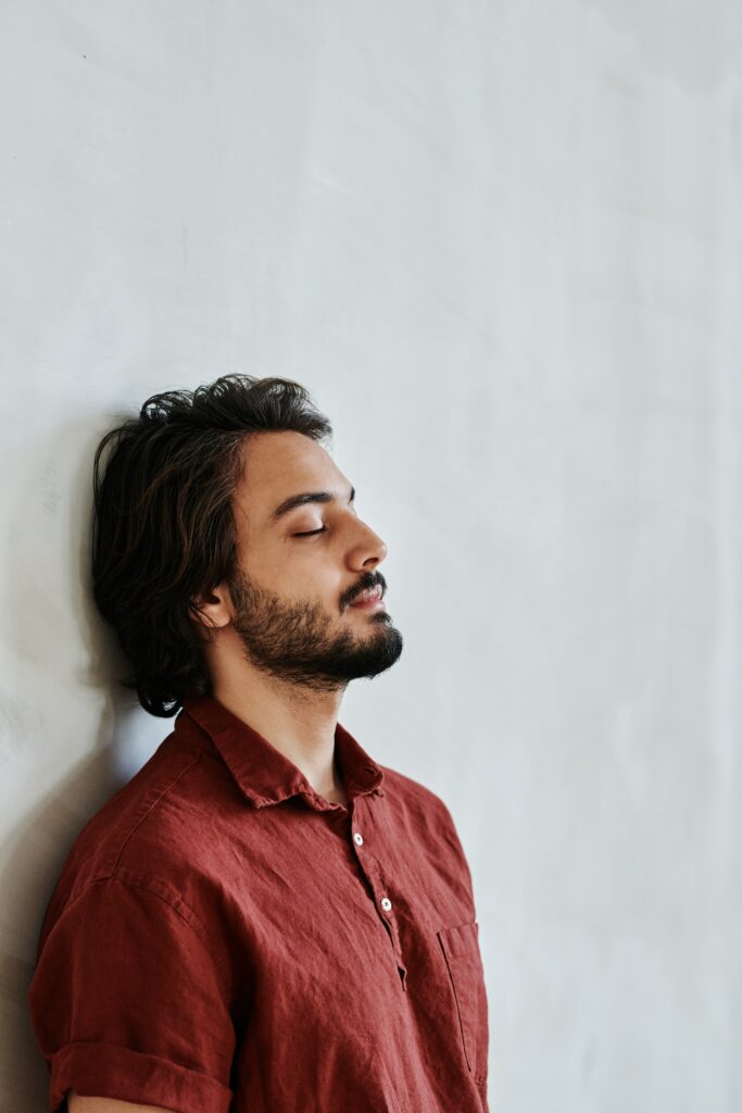 man sitting with back against wall